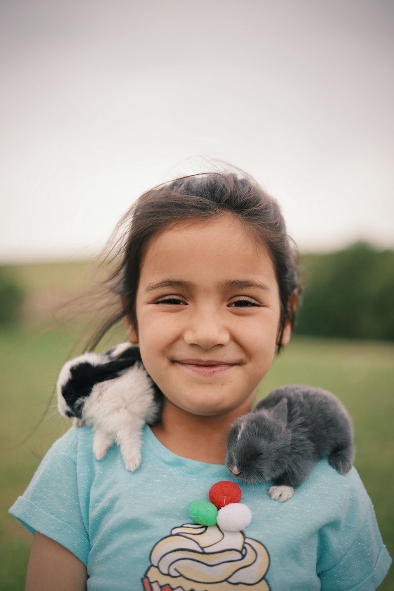 Close-Up Shot of a Smiling Girl with Rabbits on Her Shoulders