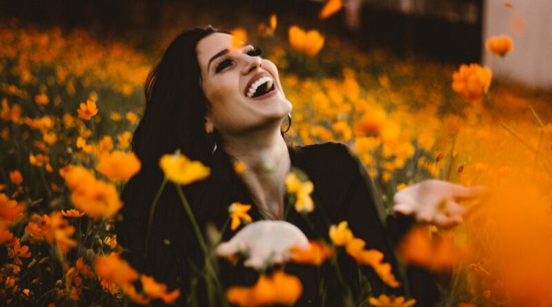 woman laughing on flower field